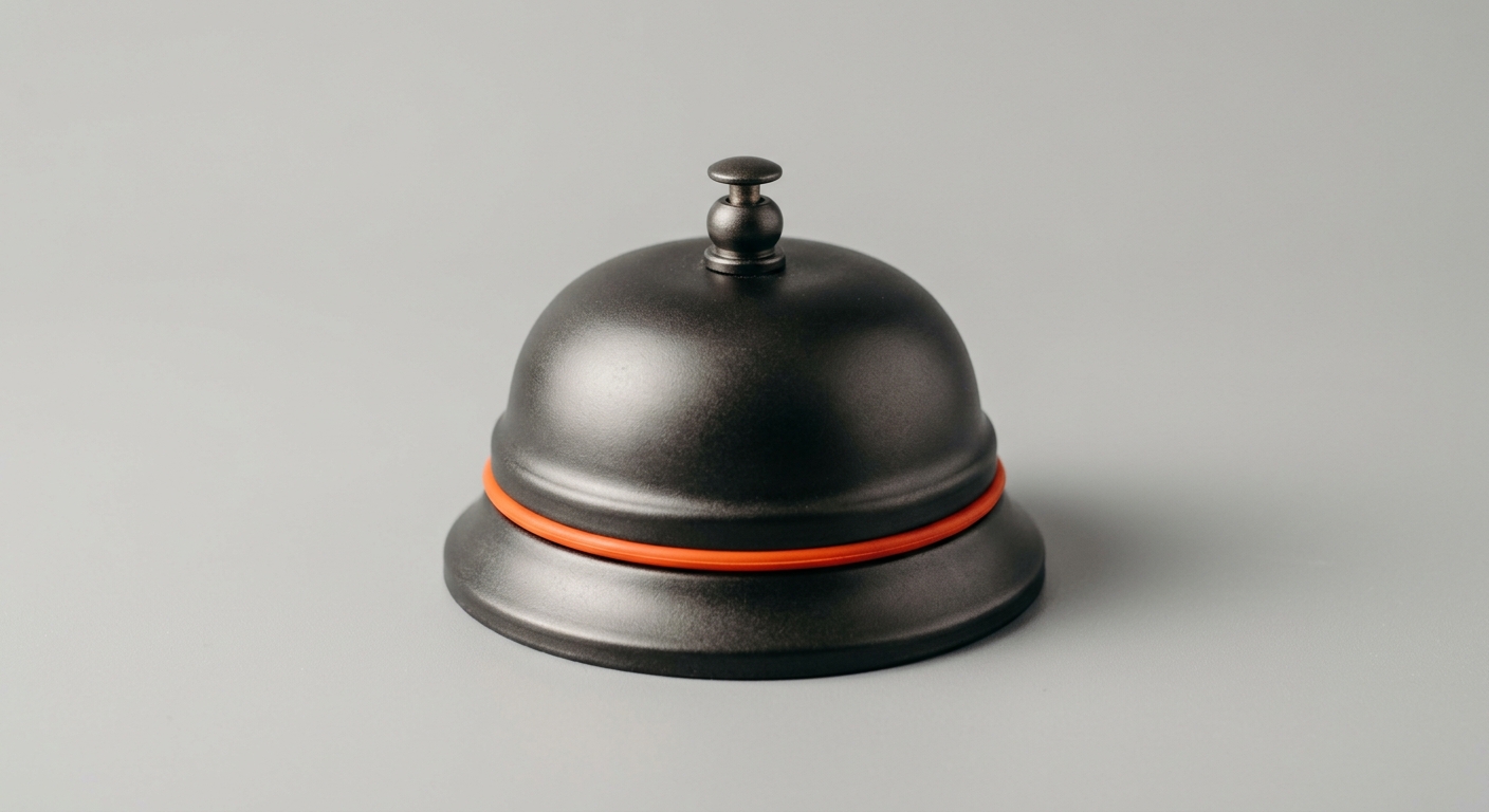A dark metal reception call bell with an orange ring, representing the quick questions people ring their experts for